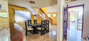 a dining room with a black table and chairs at casa bayaguana in Bayaguana