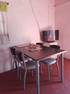 a dining room table with chairs and a television at La Vuelta del Río in Panaholma