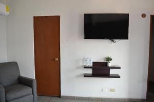 a living room with a television on a wall at Hotel CASA PETRI in Ensenada