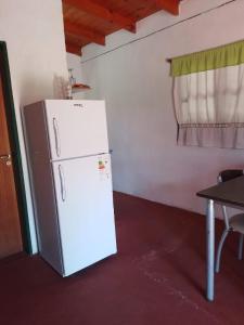 a white refrigerator in a room with a table at La Vuelta del Río in Panaholma