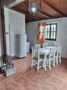 a kitchen with a white table and chairs and a refrigerator at La Vuelta del Río in Panaholma
