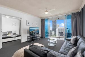 uma sala de estar com um sofá e uma televisão em Enjoy Ocean Views at Chevron Renaissance - Two Bedroom Apartment - Wow Stay em Gold Coast