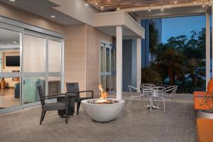 eine Feuerstelle auf einer Terrasse mit Stühlen und einem Tisch in der Unterkunft Home2 Suites by Hilton Tallahassee State Capitol in Tallahassee