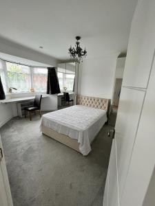 a white bedroom with a bed and a desk at Fantastic Resting house in London