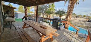 una terraza de madera con un banco de picnic y una parrilla en Horse Ranch Home 5 room 2.5 bath, en Las Vegas