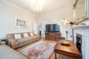 a living room with a couch and a fireplace at Stylish flat in Hampstead in London