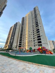 un parque infantil frente a un gran edificio de apartamentos en Comfortable & Economic Acqua Village, en Brasilia