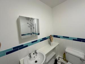 a bathroom with a sink and a toilet and a mirror at Timber Court Apartments in Central Location with FREE Parking and Netflix by RockmanStays in Stifford
