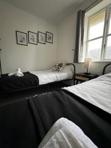 1 dormitorio con 2 camas y ventana en Timber Court Apartments in Central Grays with Free Parking and Netflix by RockmanStays en Stifford