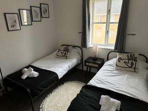 two twin beds in a room with a window at Timber Court - 2 free parking spaces - 2 Bedroom Apartment - Fast Wi-Fi - Perfect for Long Term - by Rockman Residences in Stifford