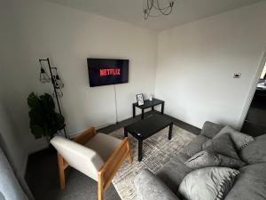 a living room with a couch and a tv at Timber Court - 2 free parking spaces - 2 Bedroom Apartment - Fast Wi-Fi - Perfect for Long Term - by Rockman Residences in Stifford +25 photos