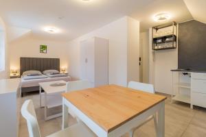 cocina y sala de estar con mesa y sillas en LIPNO Moss Apartment en Lipno nad Vltavou