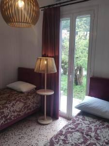 een slaapkamer met een bed en een lamp naast een raam bij Το σπίτι με τις βουκαμβίλιες in Ayia Evfimia