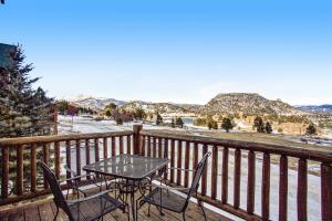 a table and chairs on a balcony with a view of the mountains at Estes Park Escape - Permit #6071 in Estes Park