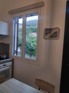 een keuken met een raam met uitzicht bij Το σπίτι με τις βουκαμβίλιες in Ayia Evfimia