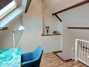 a living room with a blue chair and a window at Studio Bink in Maastricht