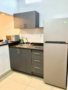 a kitchen with a refrigerator and a sink at Departamento Regiomontano in Monterrey +3 photos