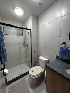 a bathroom with a toilet and a glass shower at Flat Eco Resort Carneiros in Praia dos Carneiros