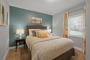 Un dormitorio con una cama con paredes azules y una ventana en 3BR free parking free Wi-Fi near dntown St Paul, en Saint Paul