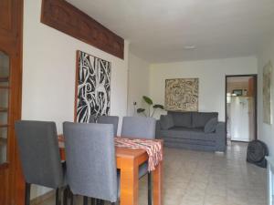 een woonkamer met een tafel en stoelen en een bank bij Departamento Brasil in Lunlunta