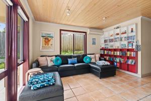 uma sala de estar com um sofá e uma estante de livros em Am Meer at Cora Lynn em Lorne