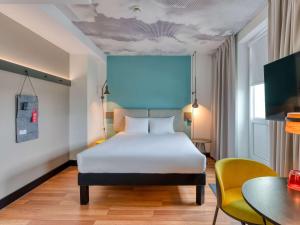 a bedroom with a white bed and a table at ibis Berlin Kurfuerstendamm in Berlin
