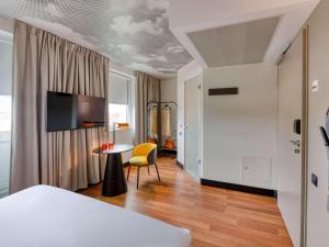 a bedroom with a bed and a table with a chair at ibis Berlin Kurfuerstendamm in Berlin