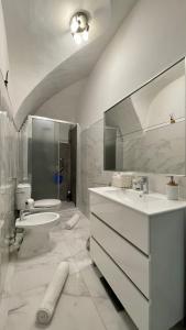 a white bathroom with a sink and a toilet at Le Bijou di Dolceacqua, per un momento memorabile. in Dolceacqua