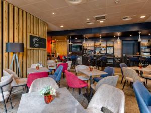 ein Restaurant mit Tischen und Stühlen und eine Bar in der Unterkunft ibis Berlin Kurfuerstendamm in Berlin