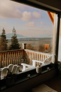 a window with chairs and a view of a deck at Kanyar - Nordic Cabin in Zebegény