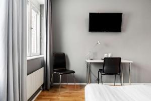 a bedroom with a desk and two chairs and a television at Sure Hotel by Best Western Stockholm Alvsjo in Stockholm