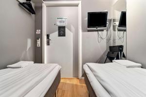 a hospital room with two beds and a tv at Sure Hotel by Best Western Stockholm Alvsjo in Stockholm