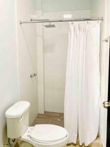 La salle de bains blanche est pourvue d'une douche et de toilettes. dans l'établissement Alojamiento completo de descanso, à Monterrey