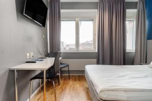 a hotel room with a bed and a desk and a table at Sure Hotel by Best Western Stockholm Alvsjo in Stockholm