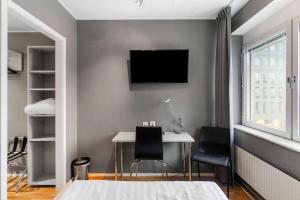 a bedroom with a desk and a tv on a wall at Sure Hotel by Best Western Stockholm Alvsjo in Stockholm