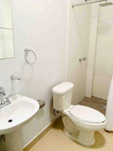 a white bathroom with a toilet and a sink at Alojamiento completo de descanso in Monterrey