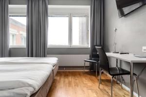 a hotel room with a bed and a desk and a window at Sure Hotel by Best Western Stockholm Alvsjo in Stockholm