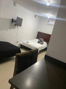 a room with a bed and a table in a room at Alojamiento completo de descanso in Monterrey +7 photos