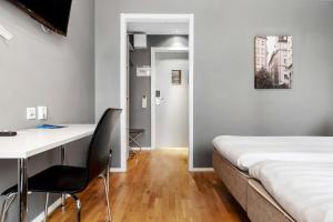 a bedroom with a bed and a desk and a desk and chair at Sure Hotel by Best Western Stockholm Alvsjo in Stockholm