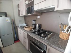 una piccola cucina con fornelli e frigorifero di ALOJAMIENTO BAHIA PELICANOS EXTENSAS y AMPLIAS VISTAS AL JARDIN a La Serena Altre 3 foto
