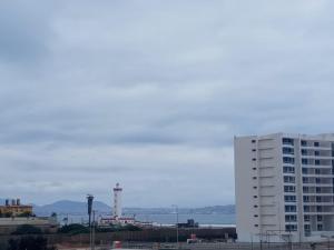 un alto edificio bianco e un faro e un edificio di ALOJAMIENTO BAHIA PELICANOS EXTENSAS y AMPLIAS VISTAS AL JARDIN a La Serena