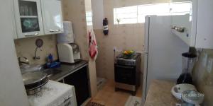 a small kitchen with a sink and a refrigerator at Mar e Descanso in Maceió