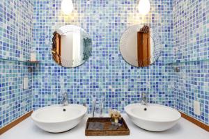 &SUN Penthouse - Vacation STAY 67587v في يوكوسوكا: حمام من البلاط الأزرق مع مغسلتين ومرايا
