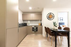 a kitchen and dining room with a table and chairs at Lotus - Sleeps 5 in Bracknell