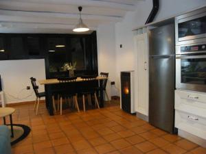 eine Küche und ein Esszimmer mit einem Tisch und einem Kühlschrank in der Unterkunft Sésamo Apartamento in Hervás