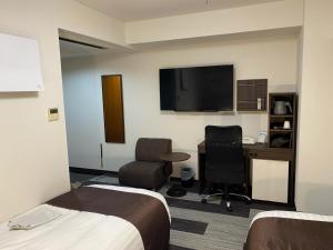 Hotel Sunny Inn - Vacation STAY 20470v في Kanonji: غرفة فندقية بسريرين ومكتب وتلفزيون