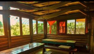une chambre avec un banc et quelques fenêtres dans l'établissement Déja vú, à Barra de Valizas