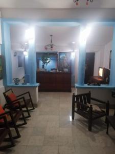 HotelCasaMorazanGranadaNicaragua في غرناطة: غرفة بها كراسي وغرفة بها جدران زرقاء
