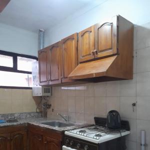een keuken met houten kasten en een fornuis met oven bij Departamento Brasil in Lunlunta