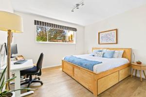 1 dormitorio con 1 cama y escritorio con ordenador en 'Kangaroo Corner' Coastal Charm & Midcentury Flair, en Sídney